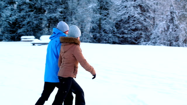 Couple-walking-in-snowy-forest