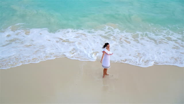 Junge-schöne-Frau-am-tropischen-Strand.-Über-Ansicht-der-glücklichen-Mädchen-in-schönen-Kleid-am-weißen-Strand