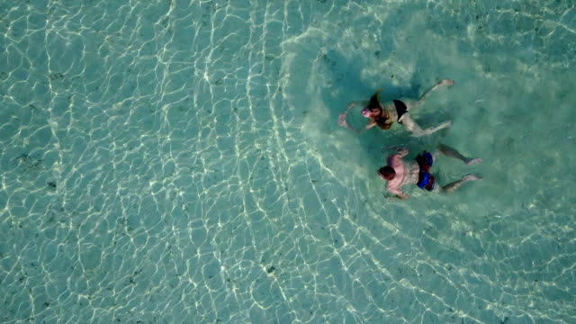 v04194-fliegenden-Drohne-Luftaufnahme-der-Malediven-weißen-Sandstrand-2-Personen-junges-Paar-Mann-Frau-Schwimmen-unter-Wasser-plantschen,-auf-sonnigen-tropischen-Inselparadies-mit-Aqua-blau-Himmel-Meer-Wasser-Ozean-4k