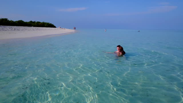 v04195-fliegenden-Drohne-Luftaufnahme-der-Malediven-weißen-Sandstrand-2-Personen-junges-Paar-Mann-Frau-Schwimmen-unter-Wasser-plantschen,-auf-sonnigen-tropischen-Inselparadies-mit-Aqua-blau-Himmel-Meer-Wasser-Ozean-4k