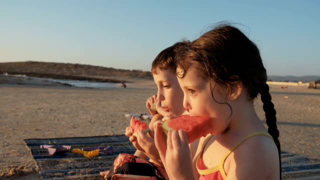 Tres-niños-comer-sandía-en-la-playa