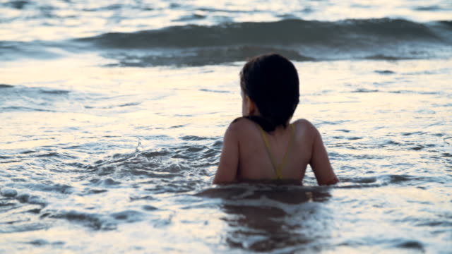 Kleine-Mädchen-spielen-am-Strand-im-Wasser-während-Sonnenuntergang-Stunde