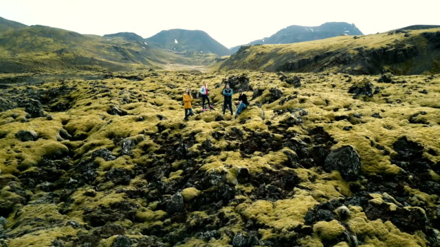 Vista-aérea-de-turistas-en-el-campo-de-lava-en-Islandia.-Copter-alejándose-de-amigos,-selfie-en-teledirigido.-Hermoso-paisaje