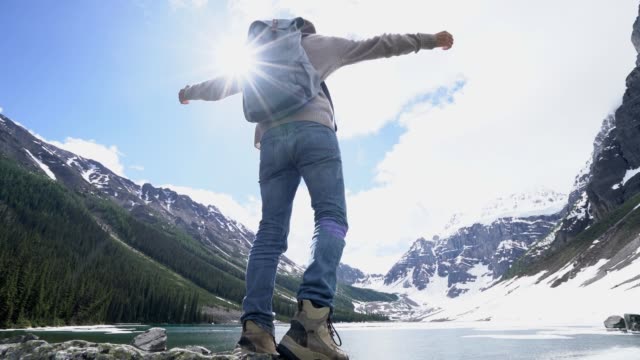 Young-hiker-reaching-lake-arms-outreached-in-nature-for-success-and-freedom