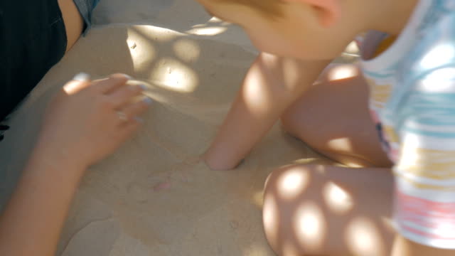 Kind-und-Mutter-am-Strand-zu-entspannen-und-spielen-mit-sand