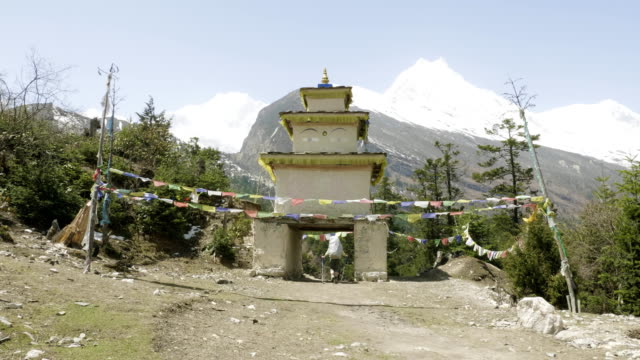 Tourist-verlässt-das-Dorf-durch-den-Torbogen-auf-trekking-im-Himalaya,-Nepal.