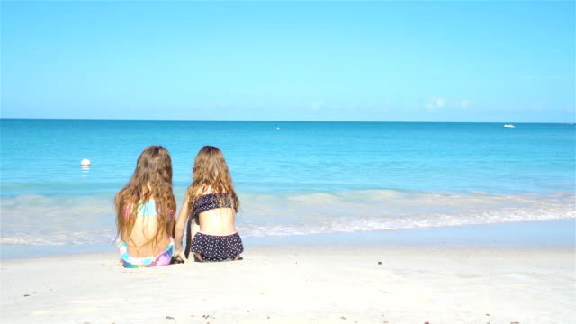 Entzückende-kleine-Schwestern-am-Strand-während-der-Sommerferien