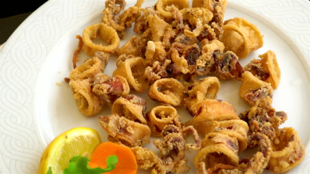 Grilled-and-fried-seafood-on-a-traditional-Mediterranean-plate-garnished-with-summer-vegetables-and-fruits---greece,-croatia,-italy,-montenegro,-squid.