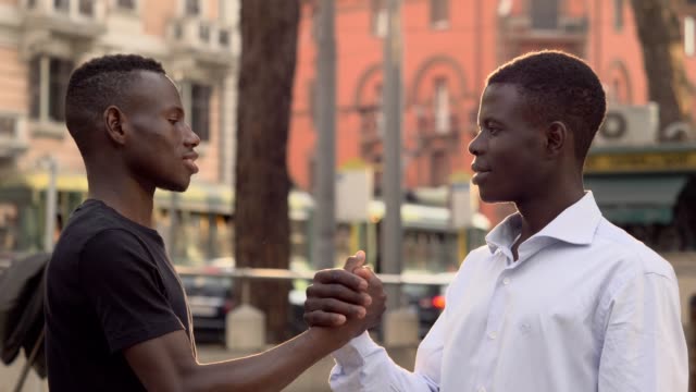 junge-afrikanische-Männer-auf-der-Straße-Gruß-lächelnd.