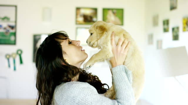 A-girl-kisses-golden-retriever-puppy