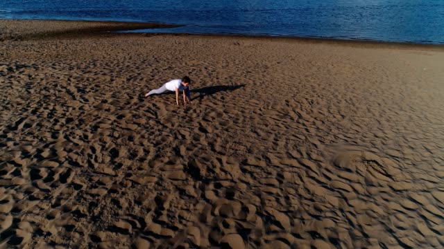 Frau-beim-Yoga-am-Sandstrand-am-Fluss-in-der-Stadt.-Schöne-Aussicht.