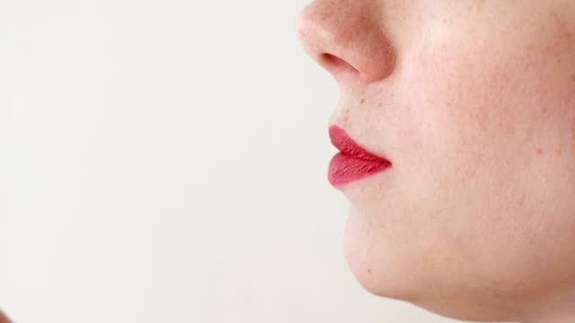 Mujer-con-labios-rojos-come-fresas.-Primer-plano-de-la-boca.-Vista-lateral.