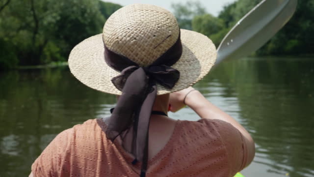 Chica-joven-canoa-en-un-lago-de-agua-soleada