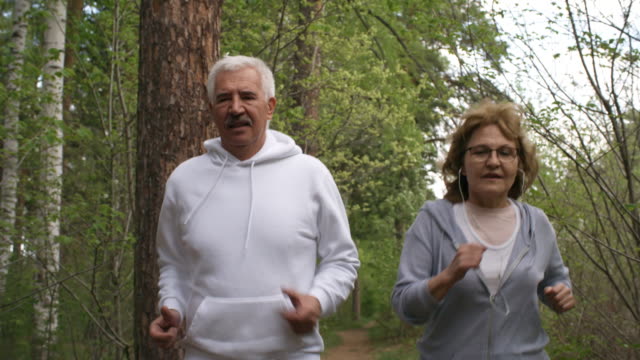 Senior-hombre-y-mujer-para-correr-en-el-bosque