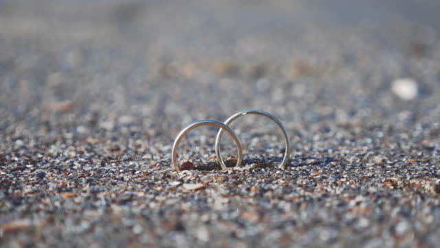 Par-de-anillos-de-boda-enterrado-en-arena