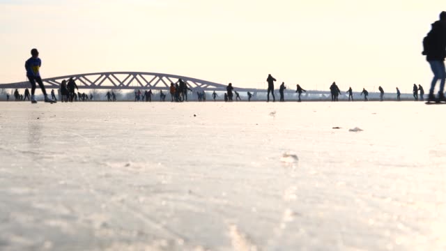 People-ice-skating-on-a-frozen-lake-next-to-the-river-IJssel-in-Holland