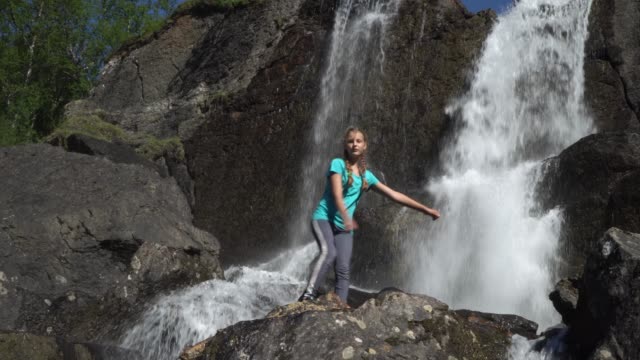 The-girl-dances-near-the-waterfall
