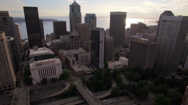 Vista-aérea-del-centro-de-la-ciudad-rascacielos-edificios-con-fondo-de-agua-en-día-soleado