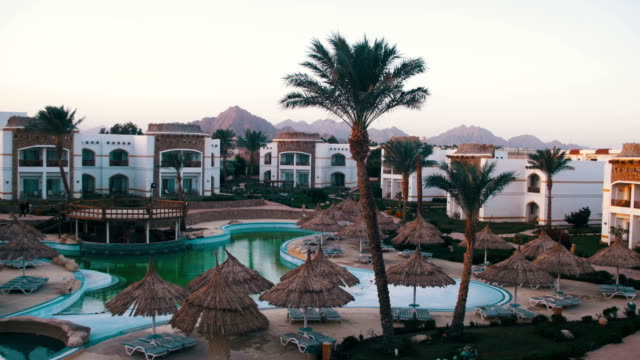Hotel-Resort-con-piscina-azul,-palmeras-y-tumbonas-en-Egipto