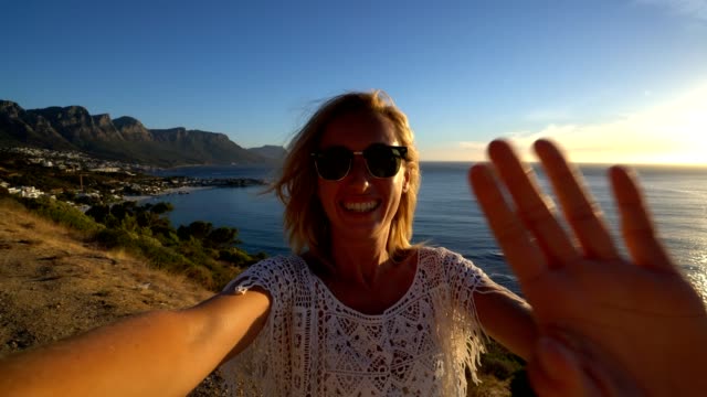 Young-woman-taking-selfie-with-seascape,-Cape-Town
