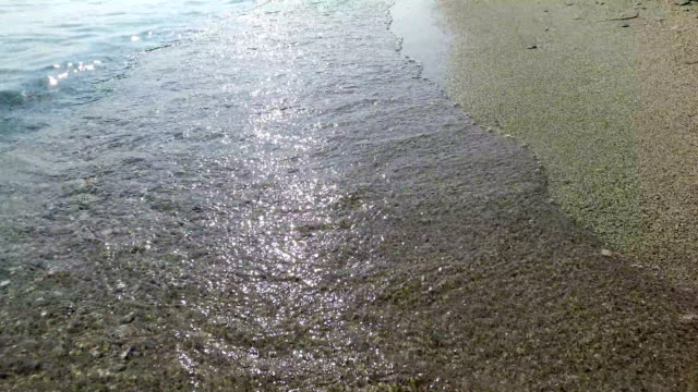 Walk-along-ses-shore-with-waves-splashing-the-sunset-sand.-4k-steadicam-pov-shot