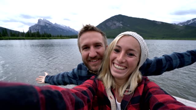 Jóvenes-tomando-selfie-por-el-lago-de-la-montaña,-Parque-nacional-Banff