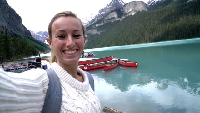 Junge-Frau-unter-Selfie-Porträt-in-Lake-Louise