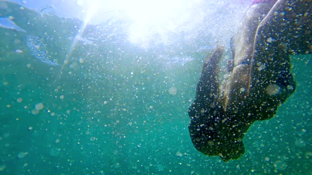 Woman-swimming-in-underwater-bubbles