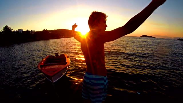 Freedom-concept,-Crane-shoot-of-successful-man-raising-hands-toward-ocean-sunset