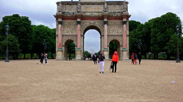 Tourists-at-Paris-landmarks-at-day,-zoom-to-ferris-wheel-over-Arc-de-Triomphe-du-Carrousel-at-entrance-of-Tuileries-Palace