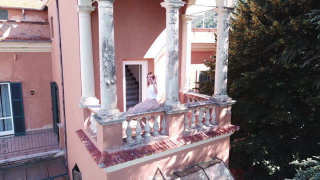 Die-junge-Frau-\"Wellenlinien\"-ihre-Hand-auf-dem-Balkon-des-alten-italienischen-villa