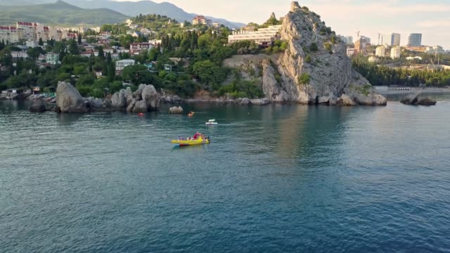 aerial-drone-flying-shot-of-cruise-touristic-catamaran-passing-by-the-sea-rocky-coast