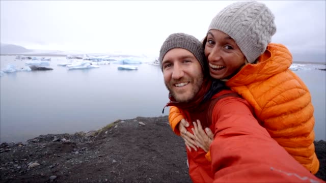 Video-de-pareja-de-jóvenes-que-se-divierten-tomando-selfie-en-el-lago-de-glaciar-en-la-laguna-Jokulsarlon-en-Islandia.