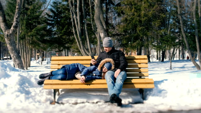Mann-und-Frau-ausruhen-zusammen-im-Winter-City-Park-auf-einer-Bank.