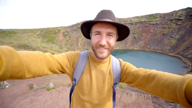 Selfie-des-männlichen-auf-Crater-Lake-Reisen-in-Island-Frühling.-Die-Leute-reisen-unbeschwerten-Lebensstil-Konzept---4K-video-Selfie-video-chat