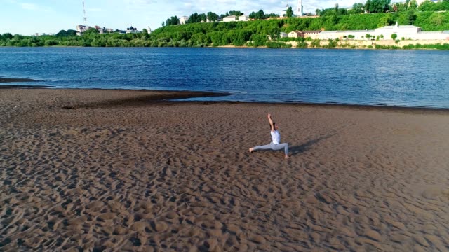 Frau-beim-Yoga-am-Strand-am-Fluss-in-der-Stadt.-Schöne-Aussicht.