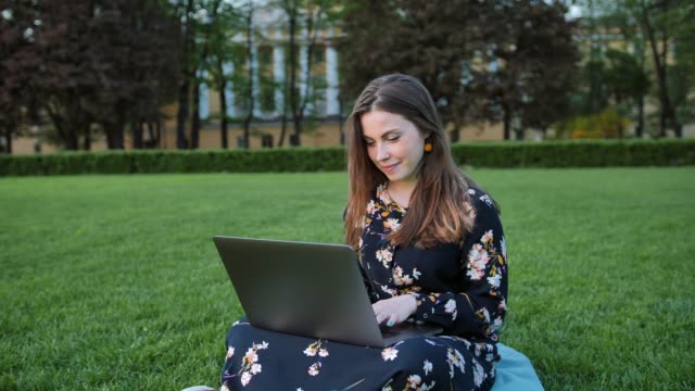 Hermosa-mujer-usando-la-laptop-en-el-parque-al-aire-libre