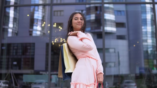 Young-girl-in-a-dress-after-shopping-with-bags-in-hands.-4K