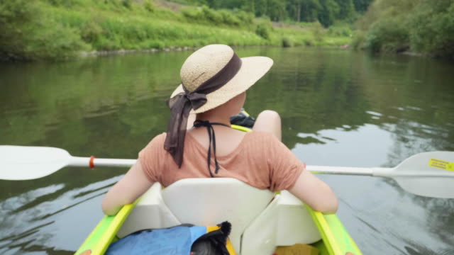 Chica-joven-canoa-en-un-lago-hermoso-y-relajarse-bajo-el-sol