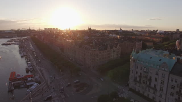 Luftaufnahme-des-Stockholmer-Stadtbild-bei-Sonnenuntergang.-Drohne-Schuss-über-Gebäude,-Straße-und-Kanal-fliegen.-Hauptstadt-von-Schweden
