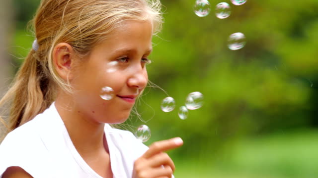 Kleines-Mädchen-spielt-mit-Seifenblasen-im-Freien.-Slow-Motion.