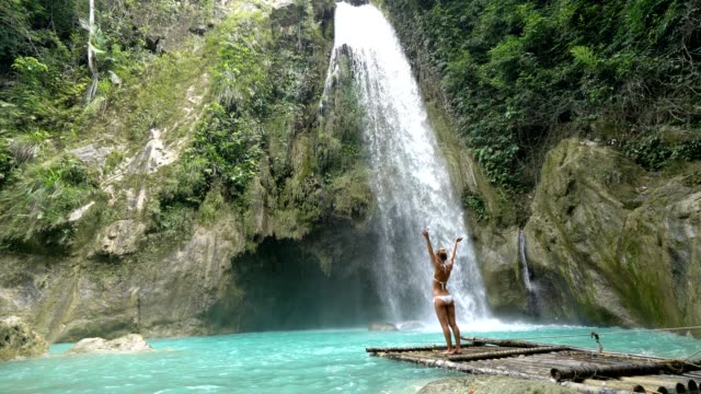 Mädchen-umarmen-schönen-Wasserfall-in-den-Philippinen---4K