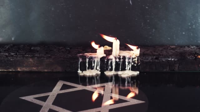 Brennende-Kerzen-auf-einem-alten-Holztisch-verbrannten-und-der-Davidstern,-Rotation-360-Grad-vor-dem-Hintergrund.