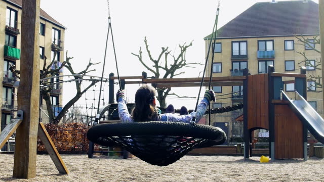 Young-woman-enjoying-outdoor-swinging-in-park,-childhood-memories,-solitude