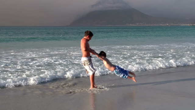 2-young-boys-playing-in-the-shallow-sea-water,-Cape-Town