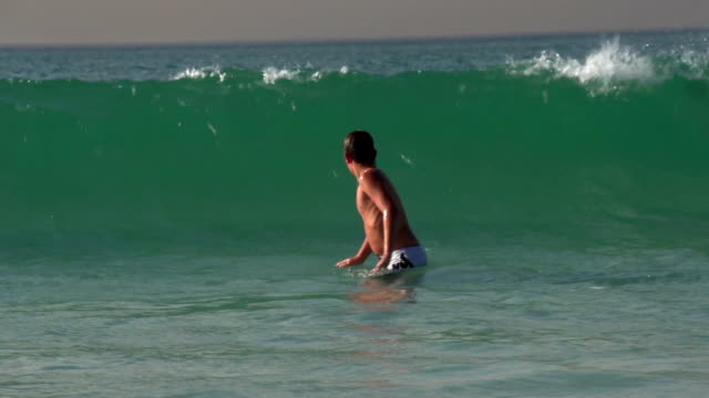 Young-boy-playing-und-Bodysurfing-in-den-Wellen,-Kapstadt,-Südafrika