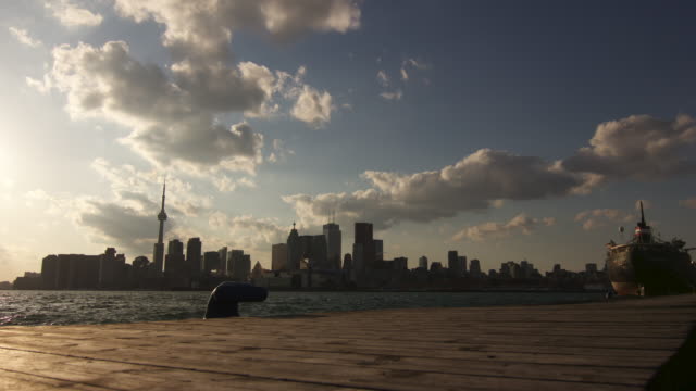 Toronto-Cityscape-Von-einem-Dock-aus-während-des-Abends-betrachtet-:-Zeitraffer