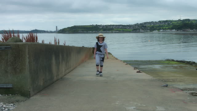 4k-Sea-View-Shot-of-a-Child-Running-on-harbour