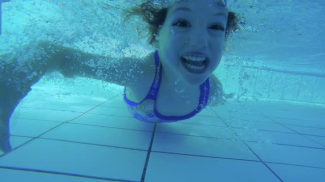 Unterwasseraufnahmen-der-Kinder-springen-und-Tauchen-im-Schwimmbad