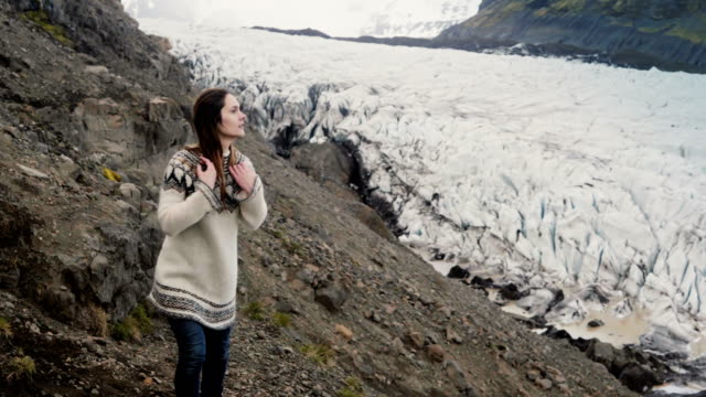 Young-beautiful-woman-exploring-the-scenic-places-in-Iceland.-hiking-in-mountains-near-the-Vatnajokull-glaciers-lagoon